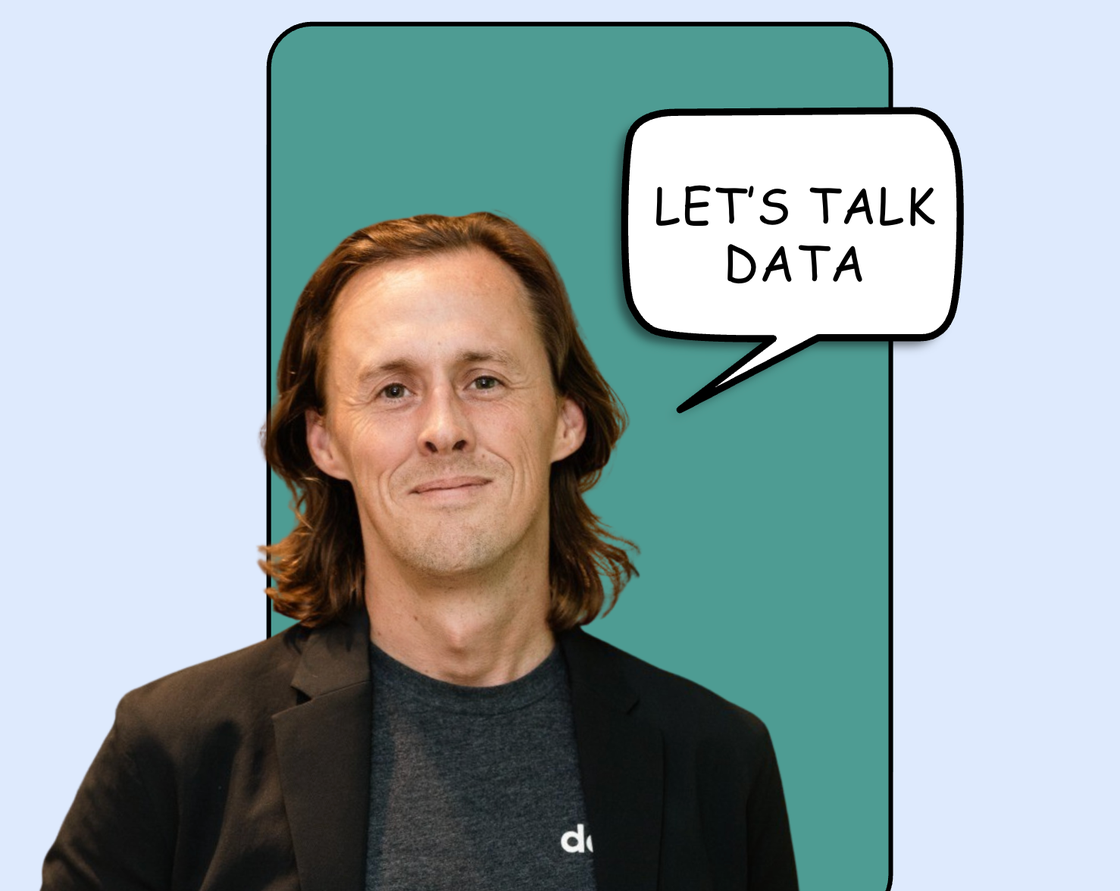 David Wrench smiling, beside a hand-drawn speech bubble reading “Let’s talk data”